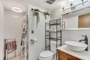 Bathroom with walk in shower, vanity, toilet, and a textured ceiling