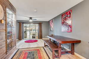 Dining area featuring ceiling fan, a textured ceiling, and light hardwood / wood-style floors