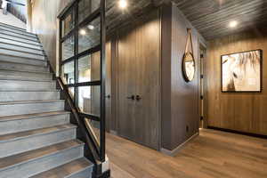 Stairs with hardwood / wood-style floors and wood walls