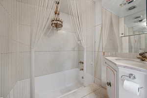 Bathroom featuring vanity and tiled shower / bath