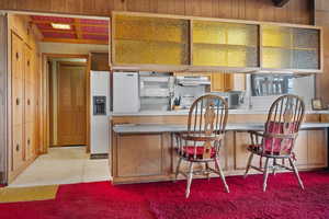 Kitchen featuring white refrigerator with ice dispenser