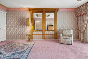 Living area with crown molding and carpet floors