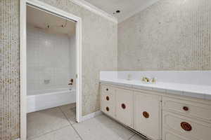 Bathroom featuring ornamental molding, a bath, tile patterned flooring, and vanity