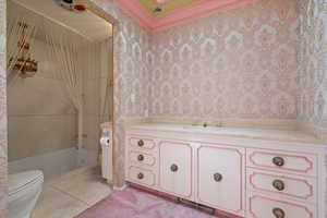 Bathroom with vanity, crown molding, and toilet