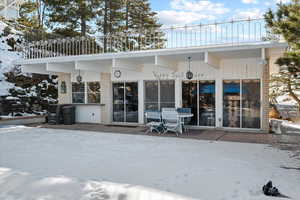 Snow covered property with a patio area