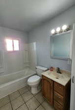 Full bathroom featuring tile patterned floors, toilet, shower / bath combination, and vanity