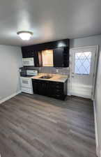 Kitchen featuring sink, hardwood / wood-style floors, backsplash, and white appliances