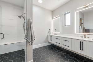 Bathroom with tile patterned floors, vanity, and a shower with shower door