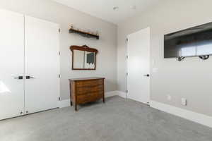 Bedroom featuring light colored carpet and a closet