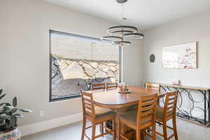 Dining space with light hardwood / wood-style floors and a notable chandelier