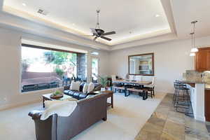 Living room with a tray ceiling and ceiling fan