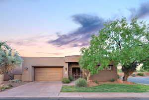 Pueblo-style home featuring a garage