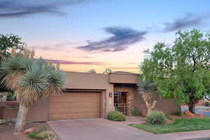 Pueblo-style house featuring a garage