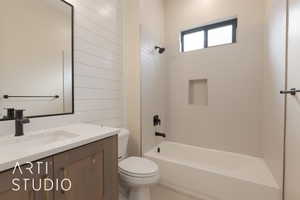 Full bathroom with vanity, tiled shower / bath combo, and toilet