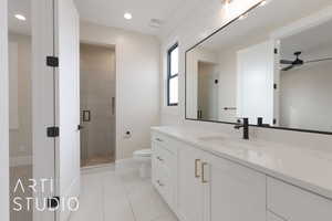 Bathroom with ceiling fan, vanity, tile patterned floors, toilet, and walk in shower