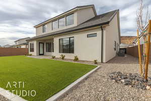 Rear view of house featuring a patio area, central air condition unit, and a lawn