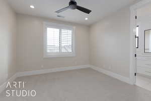 Carpeted spare room with ceiling fan