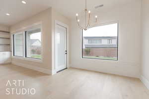 Unfurnished dining area with an inviting chandelier and light wood-type flooring