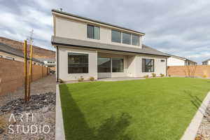 Back of property with a patio and a lawn