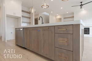 Kitchen with sink, white cabinetry, decorative light fixtures, light hardwood / wood-style flooring, and ceiling fan