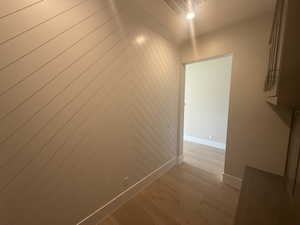 Corridor featuring wooden walls and light hardwood / wood-style floors