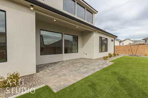 Back of property featuring a patio and a lawn