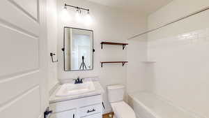 Full bathroom with vanity, bathing tub / shower combination, and toilet