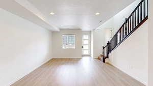 Foyer featuring a textured ceiling and light wood-type flooring