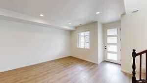 Foyer entrance featuring a textured ceiling and light hardwood / wood-style flooring