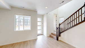 Foyer featuring light hardwood / wood-style flooring and a healthy amount of sunlight