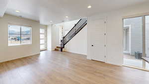 Unfurnished living room featuring light hardwood / wood-style floors and a textured ceiling