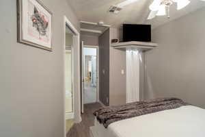 Bedroom with hardwood / wood-style floors, a textured ceiling, and ceiling fan