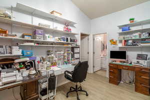 Office featuring lofted ceiling and light hardwood / wood-style flooring