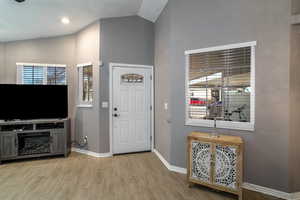 Entrance foyer featuring vaulted ceiling and light hardwood / wood-style floors