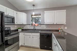 Kitchen featuring tasteful backsplash, appliances with stainless steel finishes, sink, and white cabinets