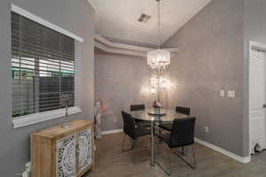 Dining space with hardwood / wood-style floors and a notable chandelier