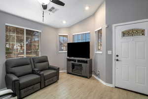 Living room featuring lofted ceiling, light hardwood / wood-style flooring, and ceiling fan