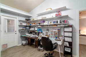 Home office featuring lofted ceiling and light hardwood / wood-style flooring