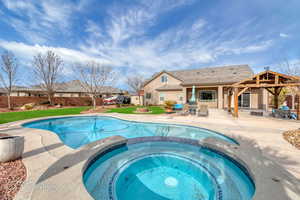 View of pool featuring an in ground hot tub, a yard, and a patio