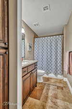 Bathroom featuring vanity, a shower with shower curtain, a textured ceiling, and toilet