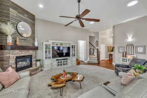 Living room featuring ceiling fan and a fireplace