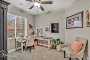 Office space with light colored carpet and ceiling fan