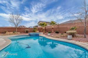 View of swimming pool featuring an in ground hot tub