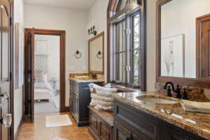 Bathroom with tile patterned flooring, vanity, and a wealth of natural light