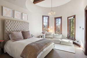 Carpeted bedroom with a notable chandelier