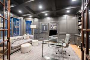Office area with ornamental molding, coffered ceiling, beam ceiling, and light hardwood / wood-style flooring