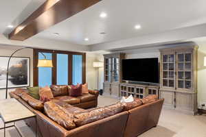 Carpeted living room featuring french doors