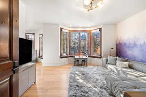 Living room featuring plenty of natural light, a chandelier, and light wood-type flooring