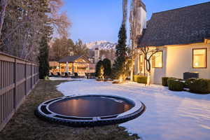 Snow covered pool with a trampoline, central AC unit, a gazebo, a mountain view, and a patio area
