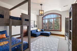 Bedroom with a notable chandelier and light colored carpet